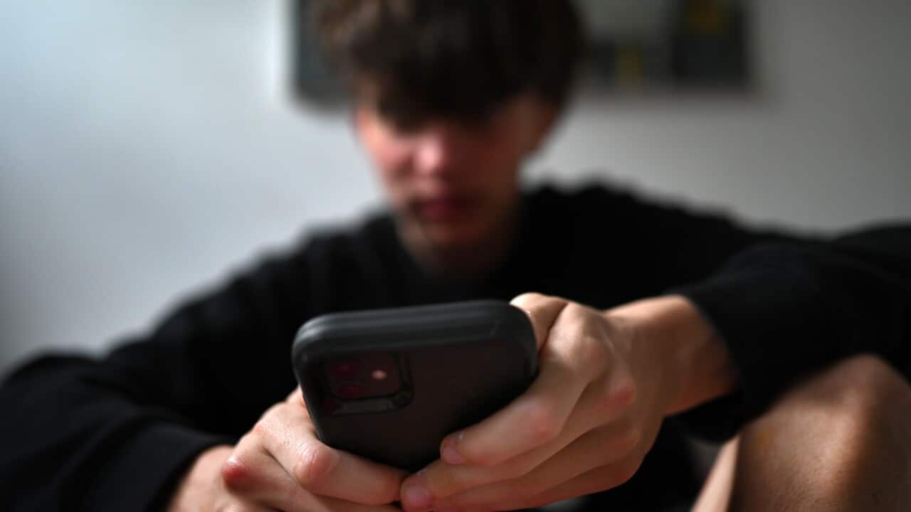 A teenager uses his mobile phone to access social media