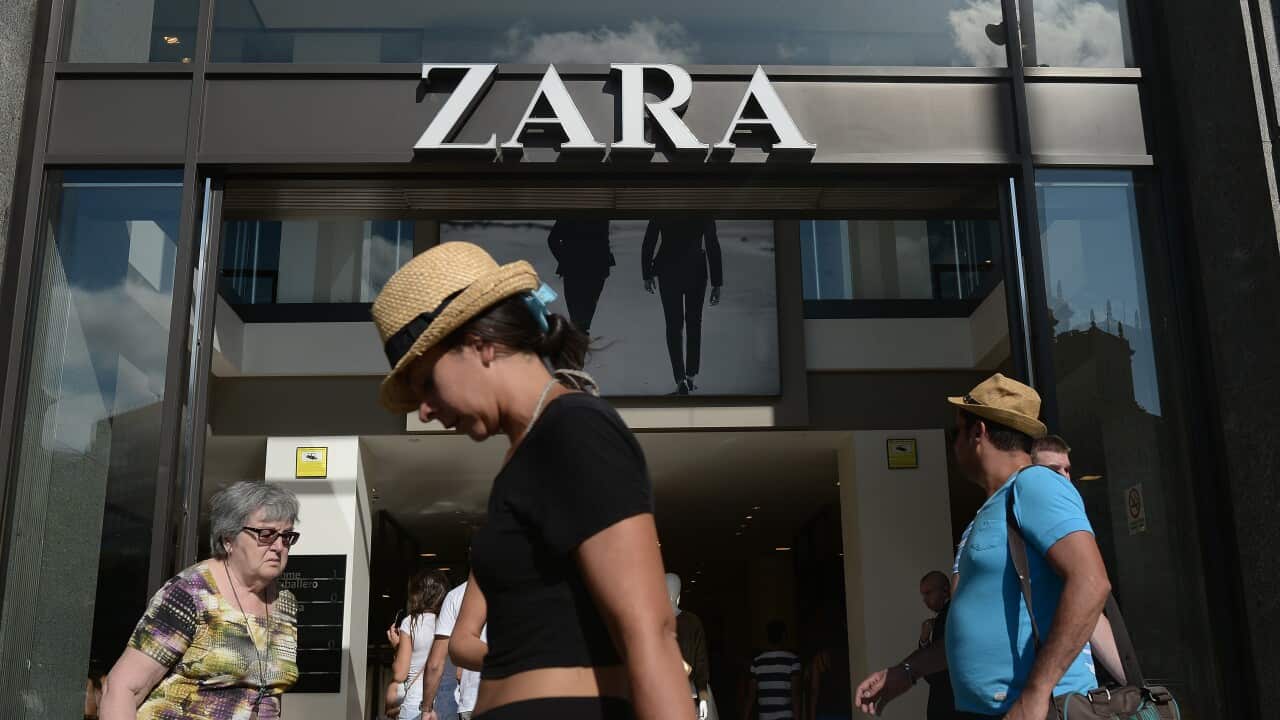 People walk past a Zara store