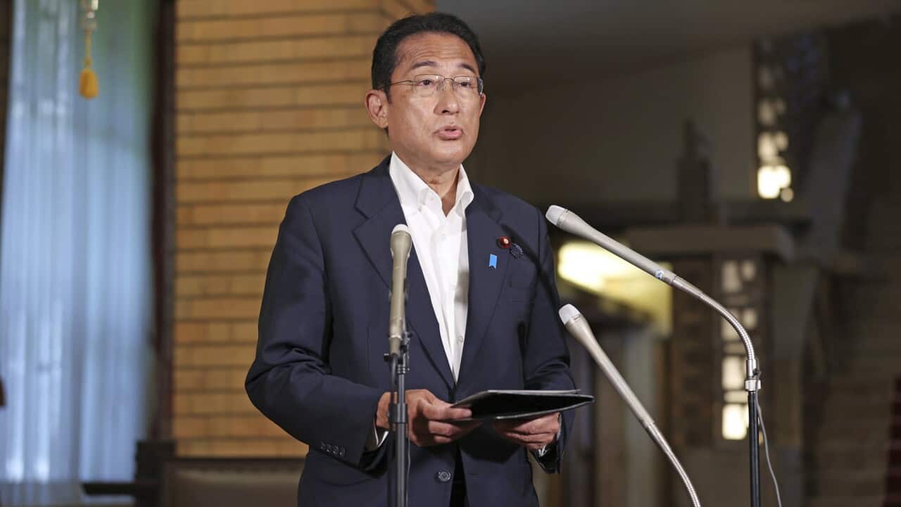 Japan's leader Fumio Kishida speaks into microphones