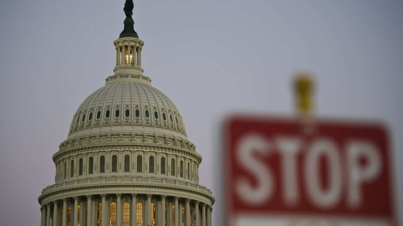 TOPSHOTSA stop sign is seen at dusk next to the US Congress building on the eve of a possible government shutdown as Congress battles out the budget in Washington, DC, September 30, 2013. AFP PHOTO/ MLADEN ANTONOV