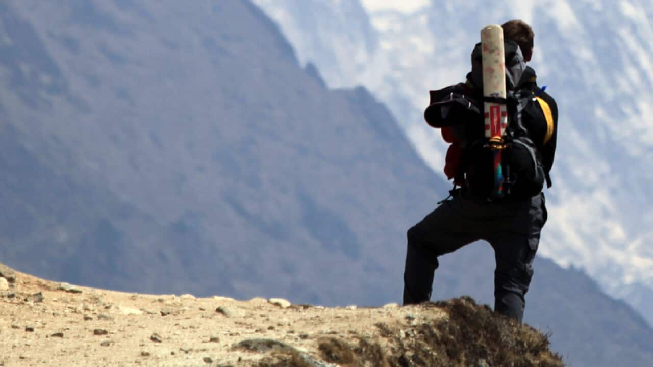 A trekker stands before Mount Everest