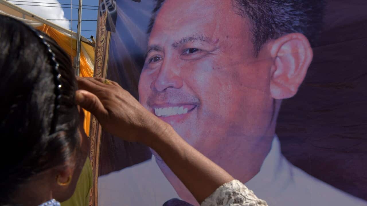 A Cambodian woman looks at a portrait of prominent Cambodian critic Kem ley during the first anniversary of his murder