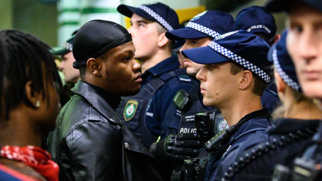 A protestor faces a police officer inside Central Station after a Black Lives Matter rally in Sydney.
