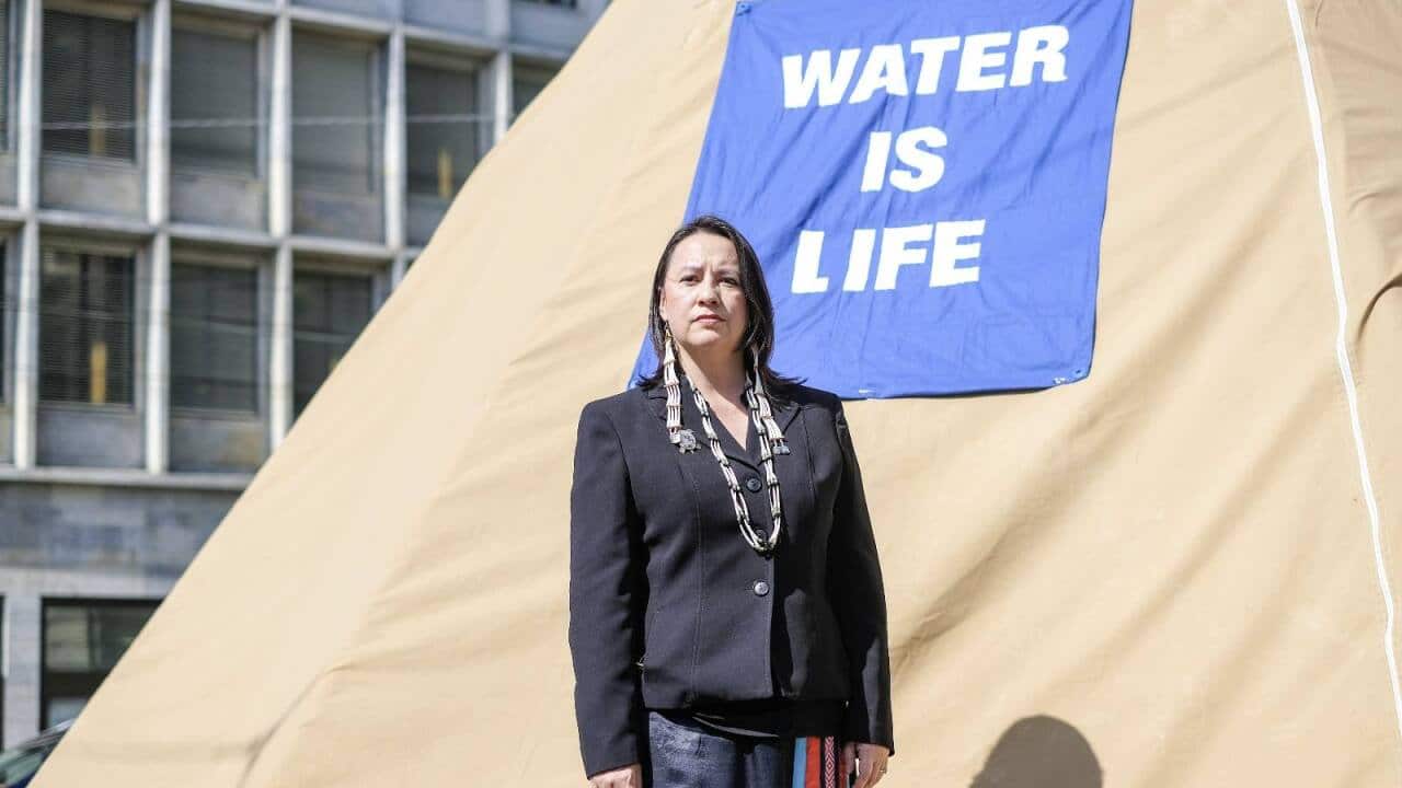 Woman stands in front of tent