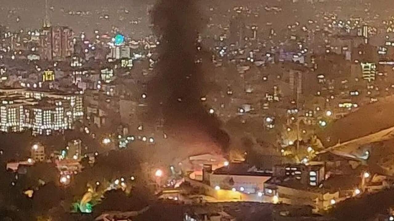 Smoke billows from a building in a city