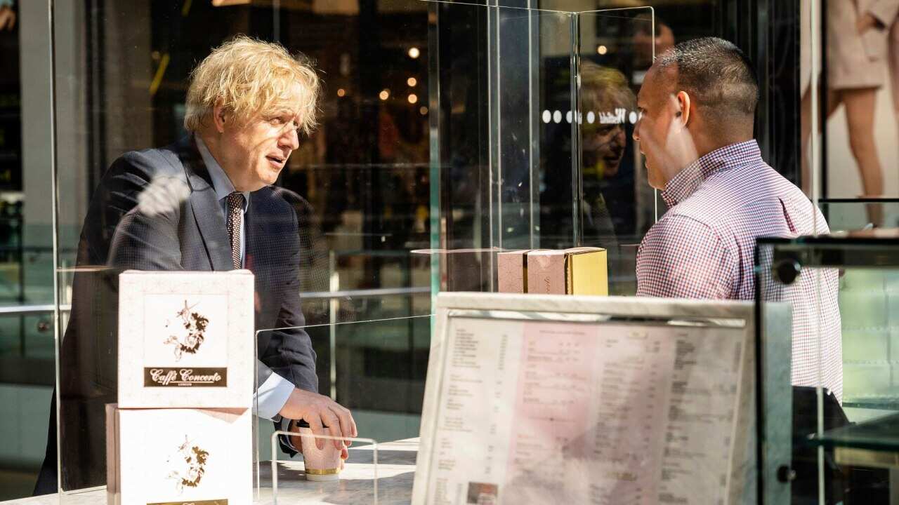 British PM Boris Johnson talks to a cafe worker at a London shopping centre