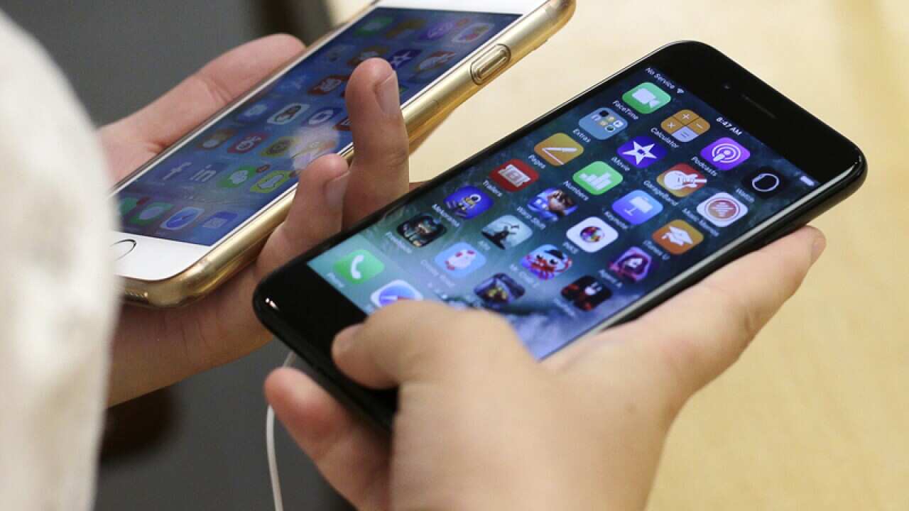 A customer compares iPhones in an Apple Store