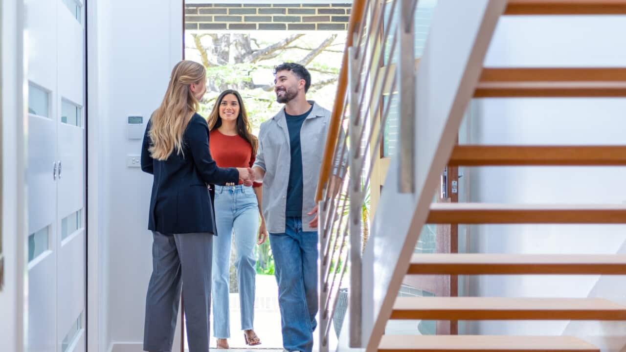 Real estate agent showing a young couple a new house.