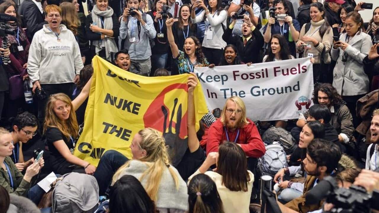 Activists hold a sit-in in front of a COP23 side event.