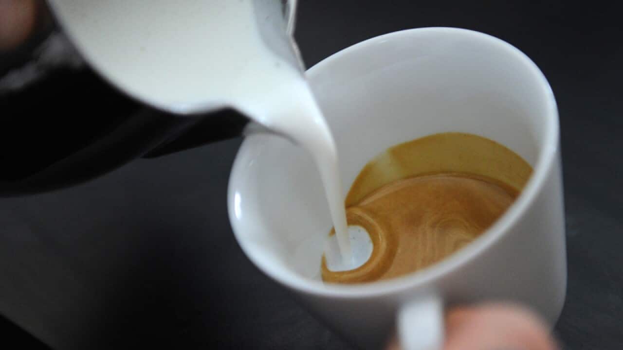 A barista makes coffee