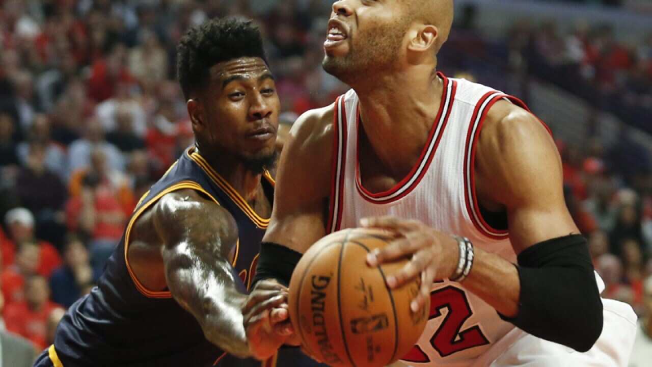 Chicago forward Taj Gibson is defended by Cleveland's Iman Shumpert.