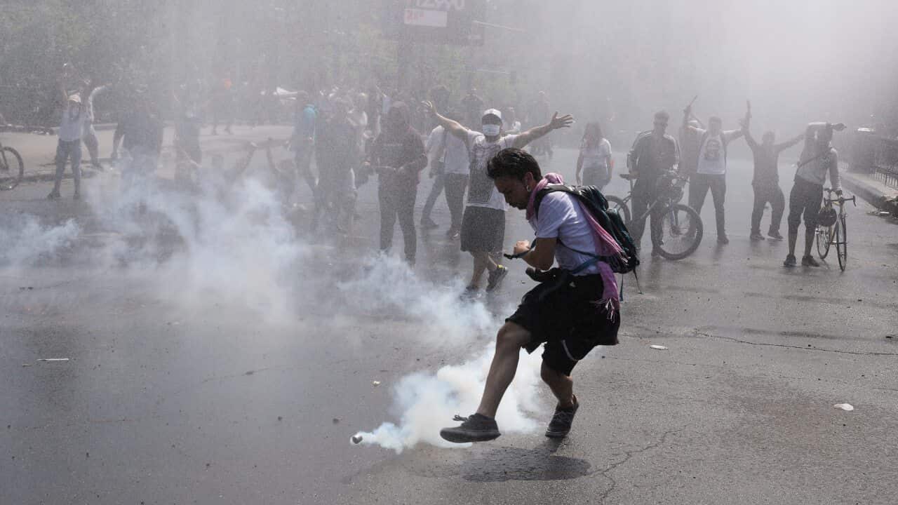 A protester kicks a tear gas canister during clashes with police in Santiago, Chile.