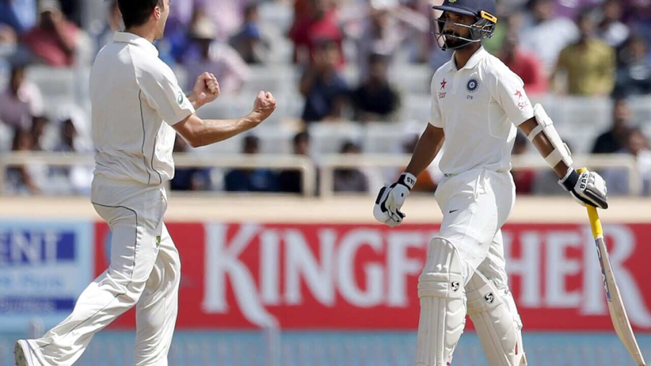 Pat Cummins, left, celebrates the dismissal of India's Ajinkya Rahane,