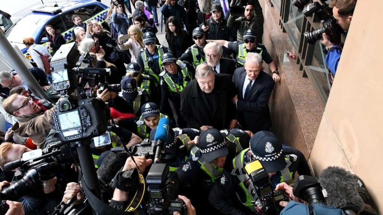 Cardinal George Pell surrounded by media outside court