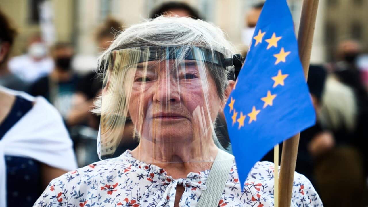 A woman wears a protective face shield and holds EU flag during an anti-domestic violence protest at the Main Square in Krakow, Poland on July 25.