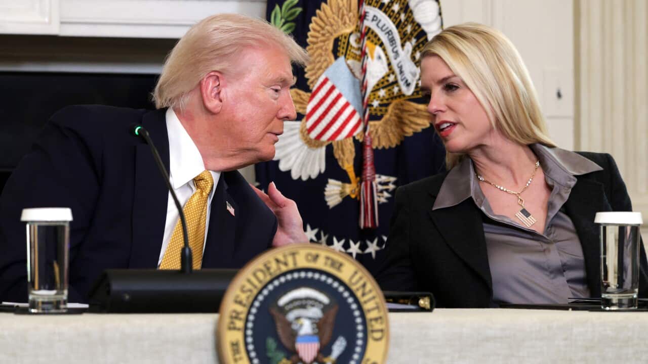 President Trump leaning over and speaking with his Attorney General Pam Bondi.