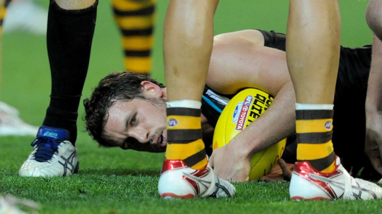 Travis Boak of Port Adelaide is tackled, against the Hawthorn