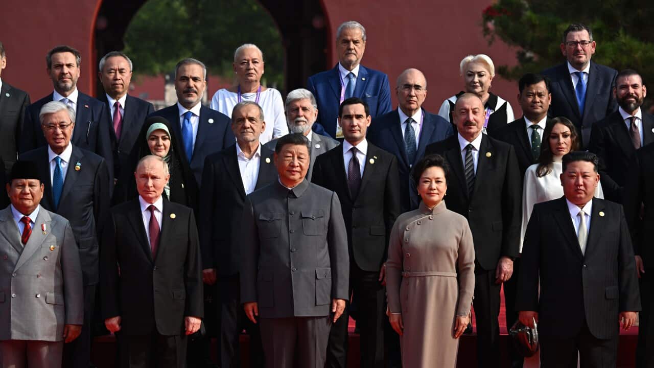 A group photo of men and women in formal attire.