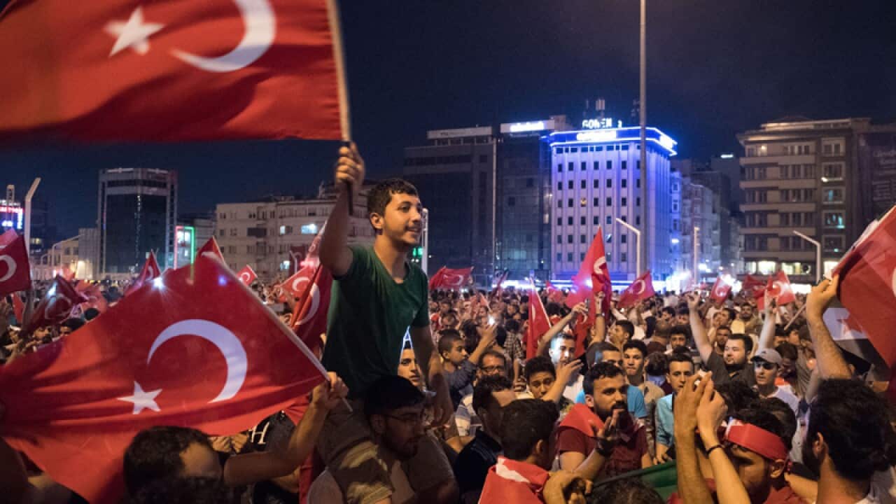 People shout slogans and hold Turkish national flags