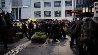 A large group of police marching down a busy road.
