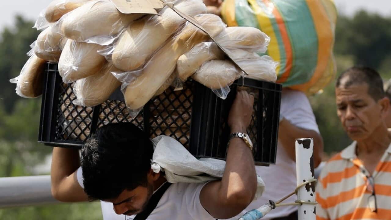 A Venezuelan man carries bread from Colombia back to Venezuela