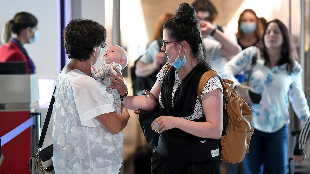 Passengers are reunited with loved-ones after arriving on the first flight from Melbourne at the Brisbane Domestic Airport