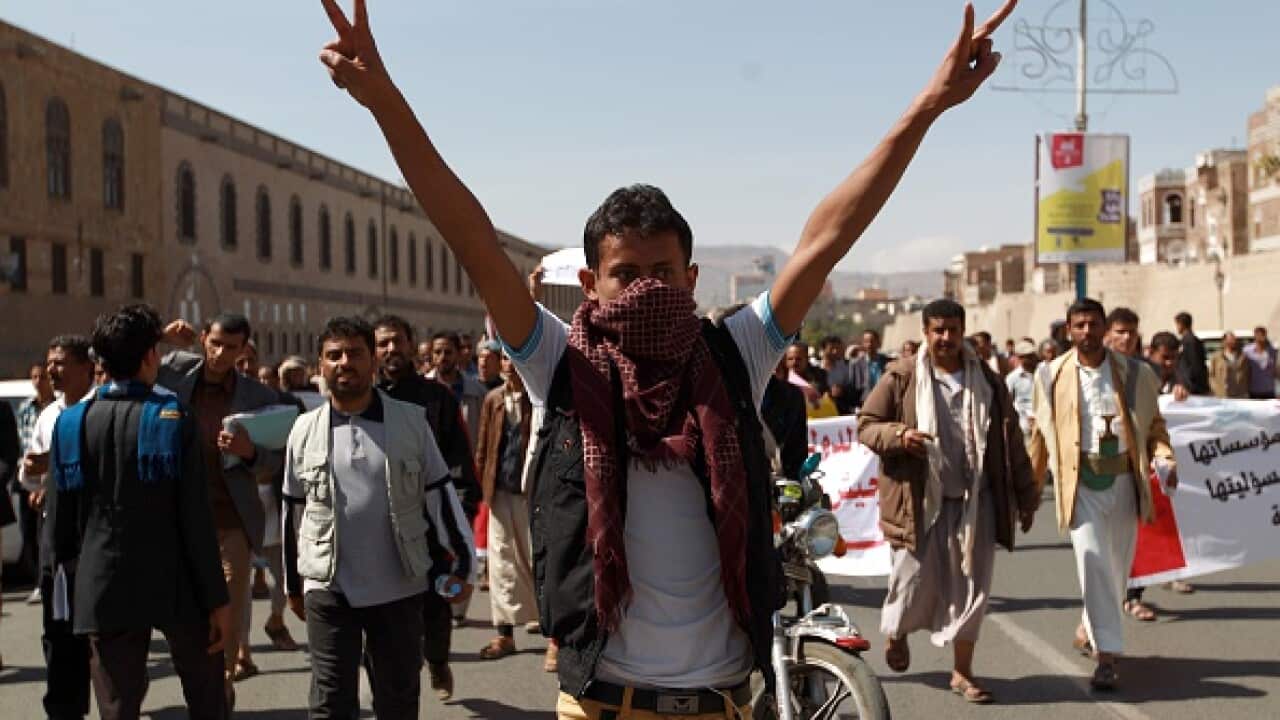 A Yemeni protester flashes the sign of victory
