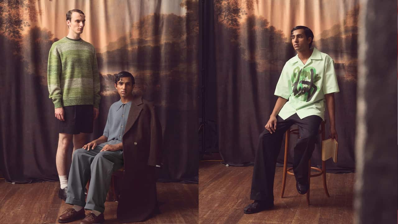 A split image shows a male model wearing a blue outfit sitting on a chair on the left, with another male model in a green jumper and black shorts standing next to him. On the right, a male model wearing a print-patterned shirt with dark trousers poses on a chair.