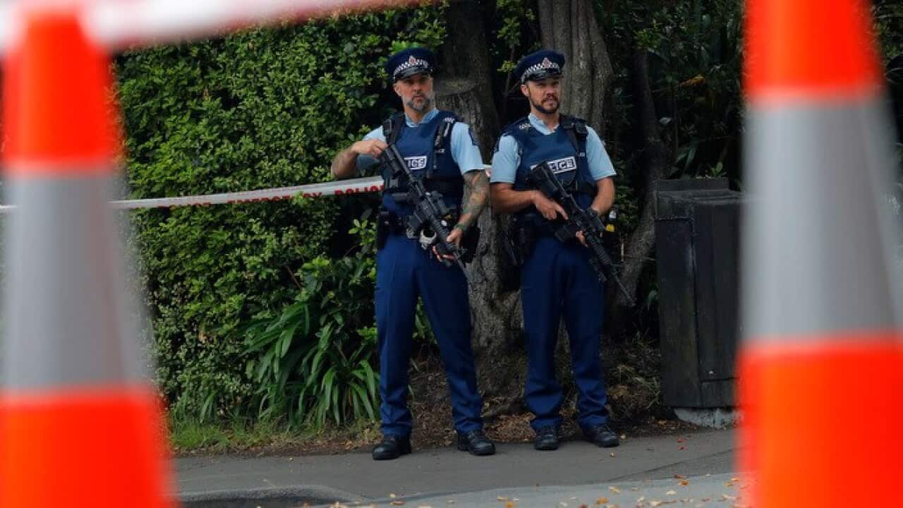 Armed police officers stand guard outside the Masjid Al Noor mosque in Christchurch