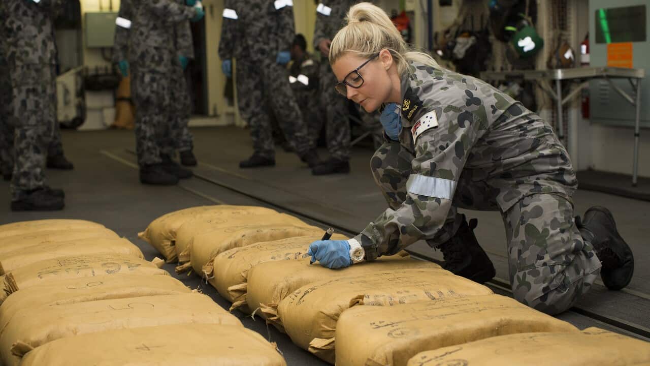 Leading Seaman Naval Police Coxswain Jamie Janes numbers narcotic parcels seized by HMAS Warramunga.
