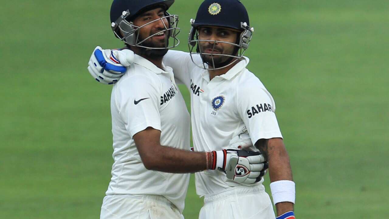 India's batsman Cheteshwar Pujara, left, with teammate Virat Kohli