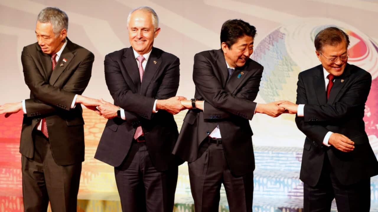 Singapore Prime Minister Lee Hsien Loong, Australia Prime Minister Malcolm Bligh Turnbull, Japan Prime Minister Shinzo Abe and South Korea President Moon Jae-in link arms