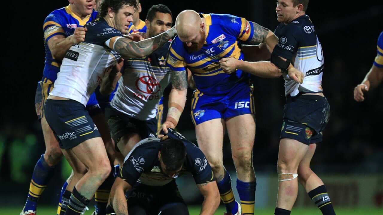 Leeds Rhinos' Mitch Garbutt (centre) punches Cowboys James Tamou