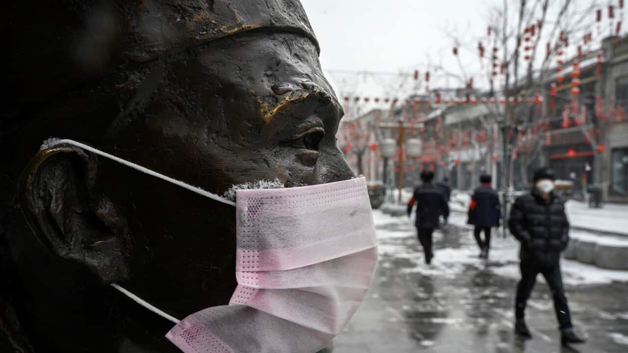 A protective mask on a statue outside a restaurant in Beijing