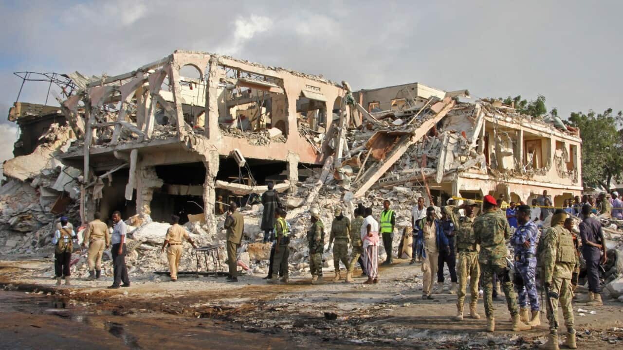 Somali security forces and others gather and search for bodies near destroyed buildings at the scene of Saturday's blast, in Mogadishu, Somalia Sunday, Oct. 15, 