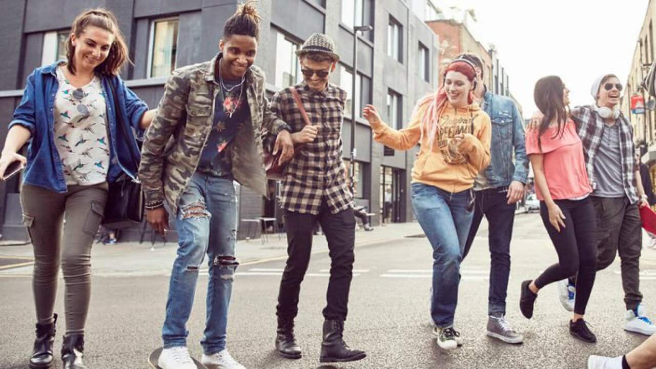 Teenage friends walk along a street