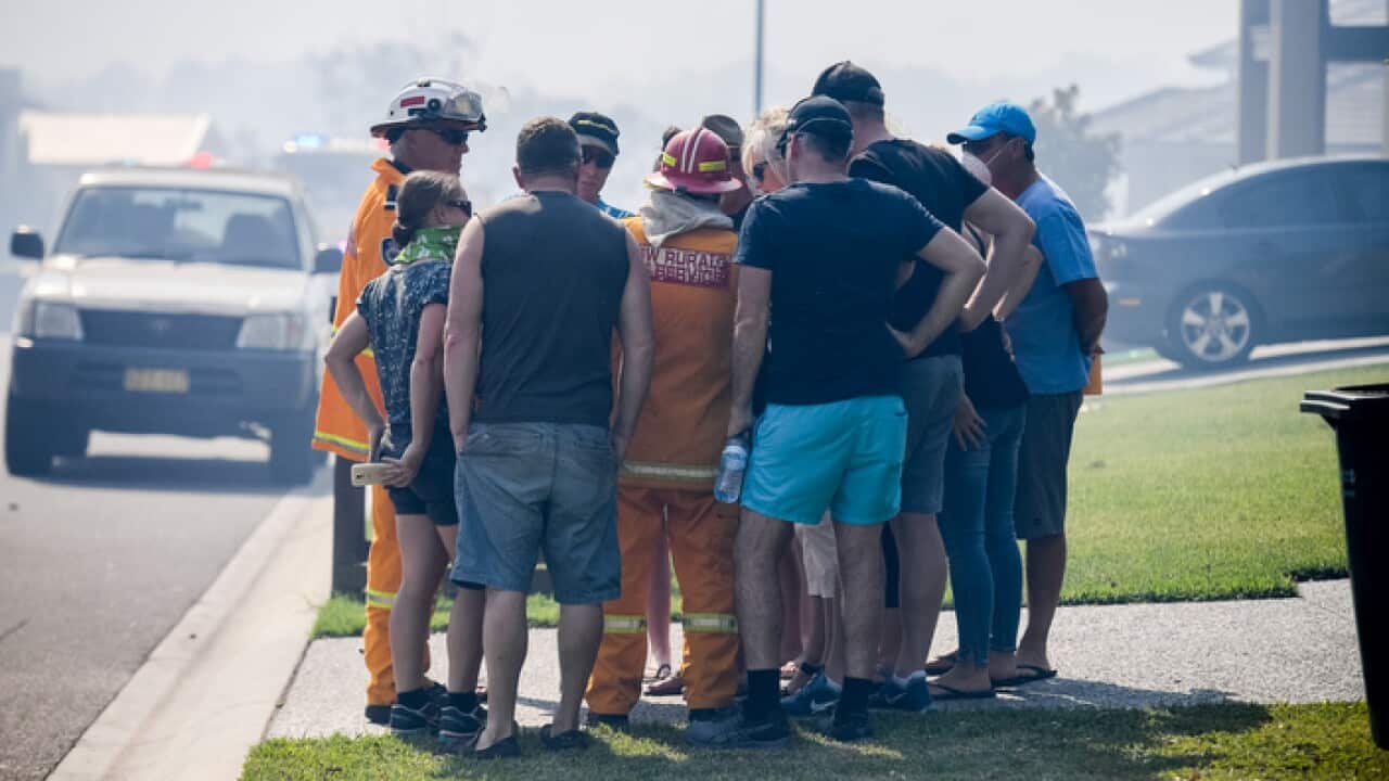Residents seek advice and information from NSW RFS fire fighter Ken Middleton(centre) in Sydney.