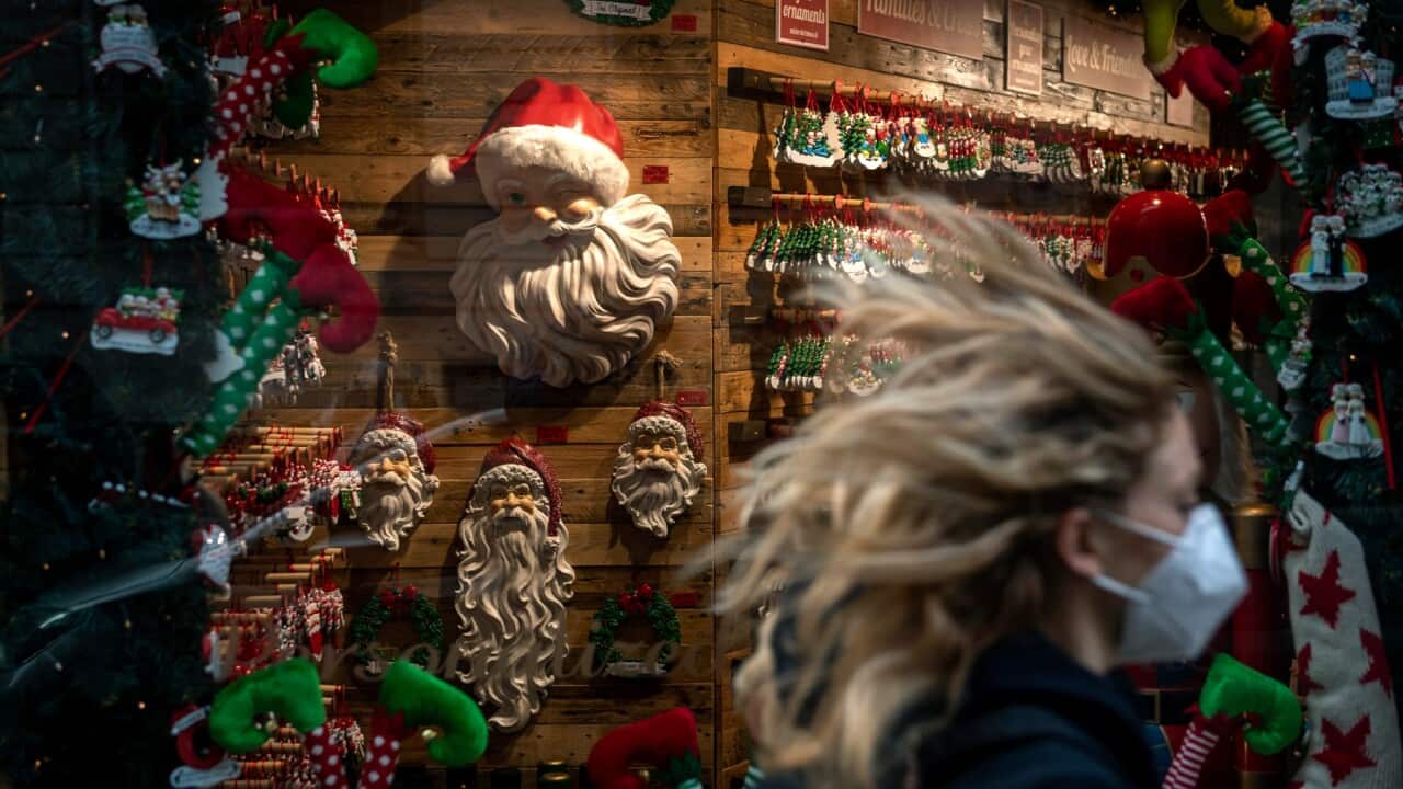 ROME, ITALY - NOVEMBER 14: A woman wearing a protective mask walks by the window of a Christmas shop at Via dei Condotti