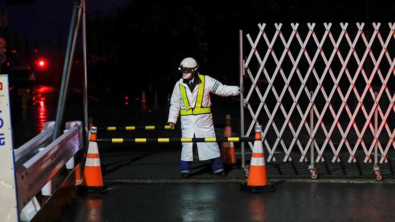 A security guard closes a street in the still heavily restricted Fukushima area