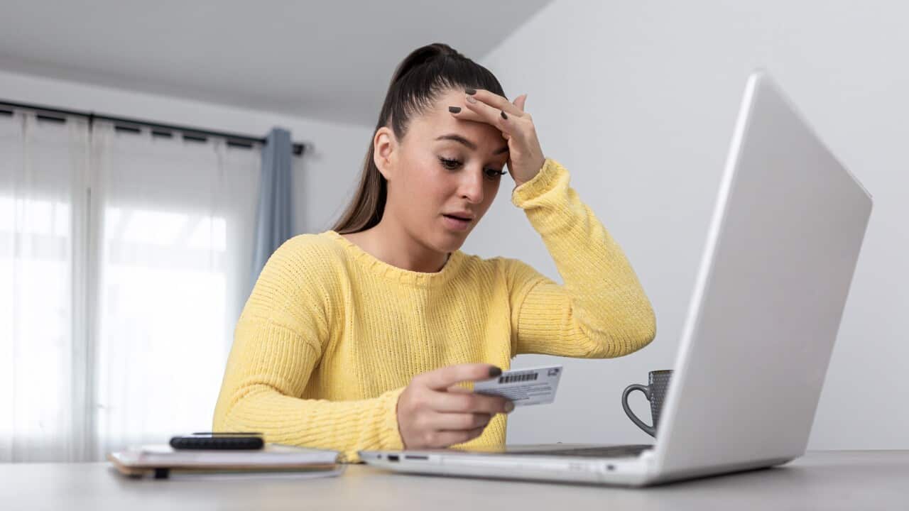 Anxious woman with credit card shopping online