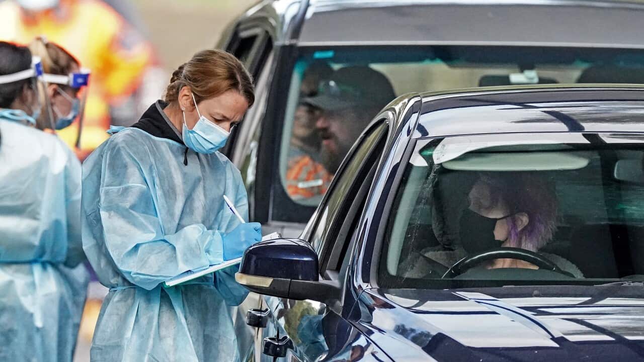 A medical worker takes a sample from a person at a drive-through COVID-19 pop-up testing clinic in Melbourne.