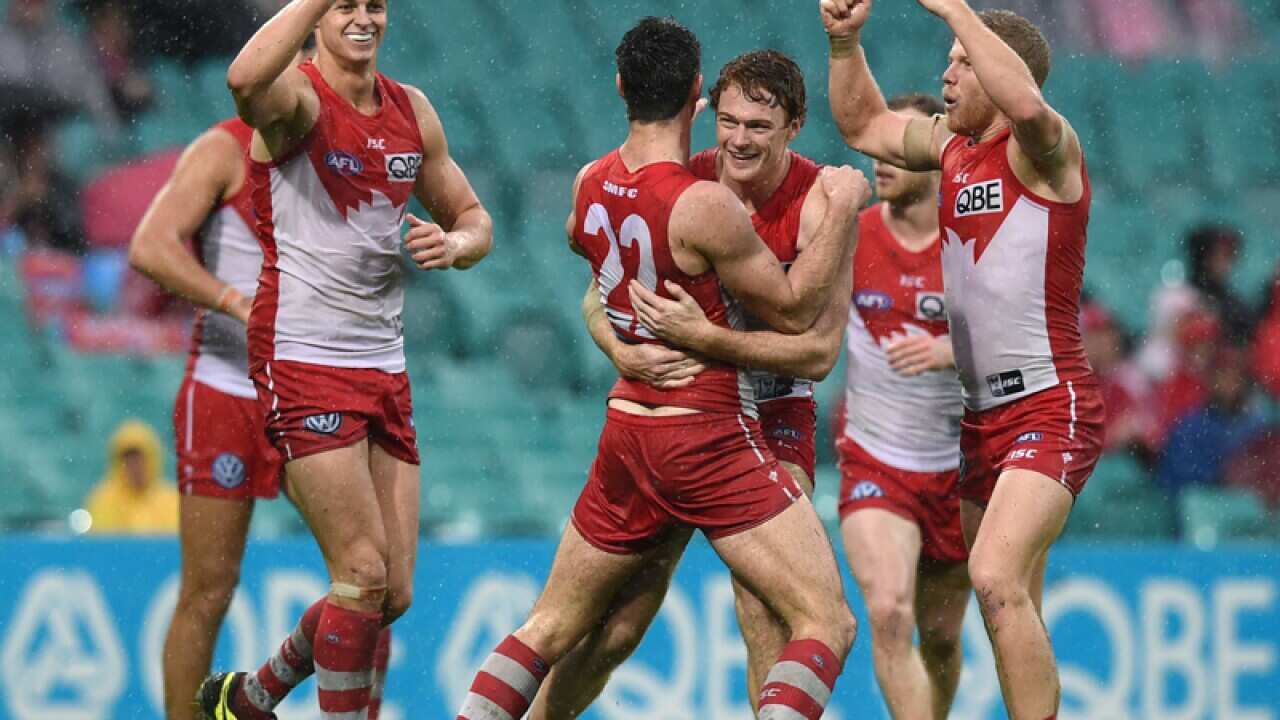 Dean Towers (C) of the Swans is congratulated after kicking a goal