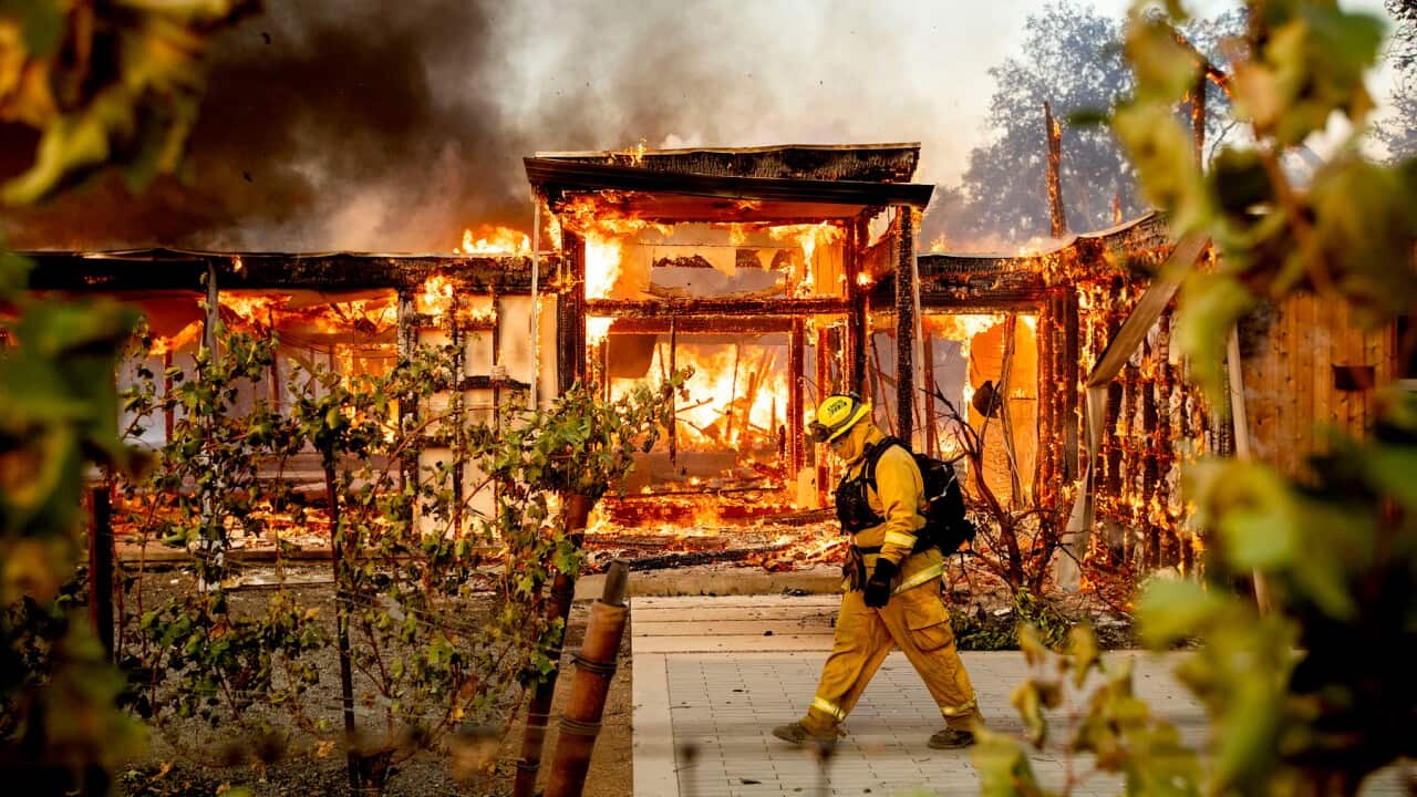 Woodbridge firefighter Joe Zurilgen passes a burning home as the Kincade Fire rages in Healdsburg, Calif., on Sunday, Oct 27, 2019. (AP Photo/Noah Berger)