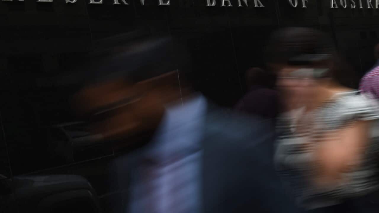 Pedestrians walk past the Reserve Bank of Australia head office