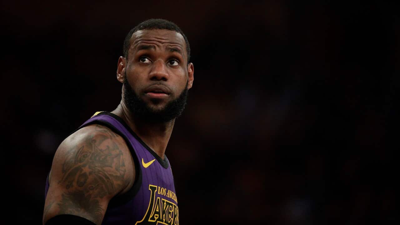 Los Angeles Lakers' LeBron James walks across the court during the first half of an NBA basketball game against the New Orleans Pelicans.