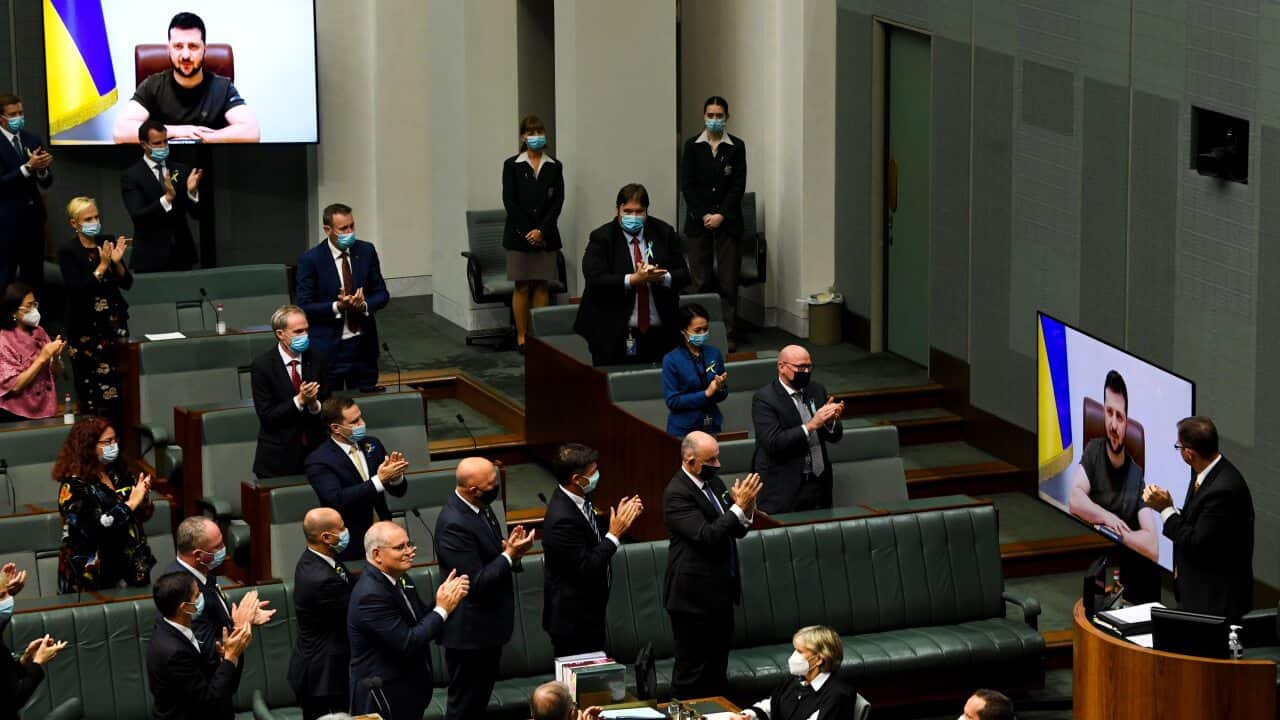 Australian members of Parliament applaud as Ukrainian President Volodymyr Zelenskyy addresses the House of Representatives via a video link at Parliament House in Canberra, Thursday, March 31, 2022. (AAP Image/Lukas Coch) NO ARCHIVING