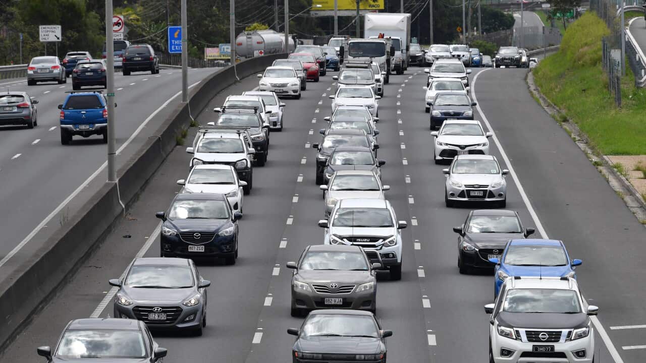 Three lanes of congested traffic on a highway.