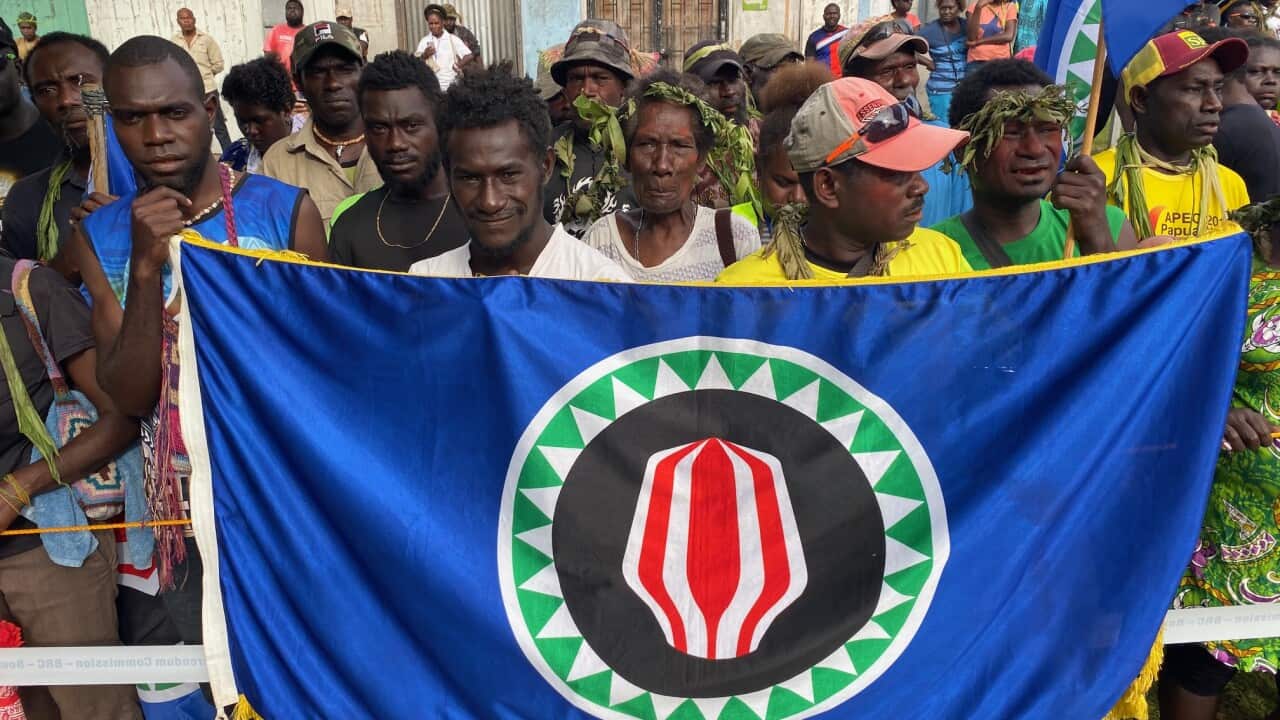 Voters proudly show off the flag of Bougainville, the symbol of the Autonomous Region of Bougainville in Papua New Guinea, as they head to cast their ballots.
