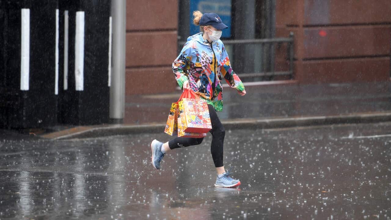Pedestrians are seen as heavy rain falls in Sydney.