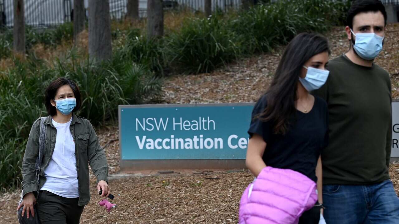 Members of the public wear face masks as they line up at the NSW Health Vaccination Hub at Olympic Park in Sydney